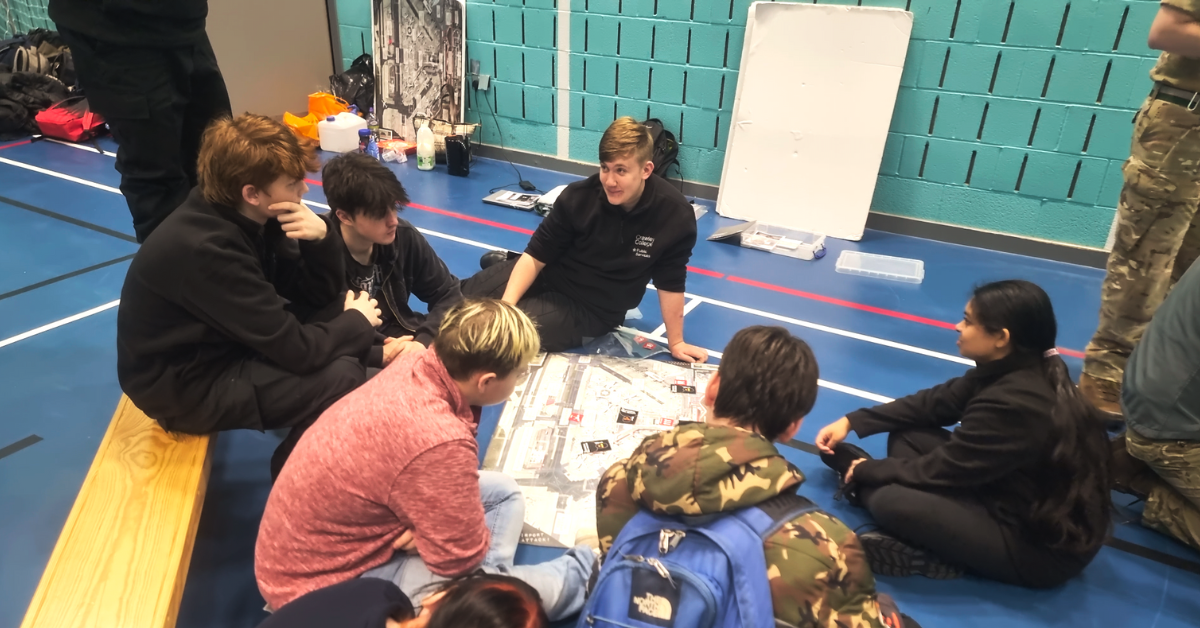 A group of students sat on the floor working on an activity over a map